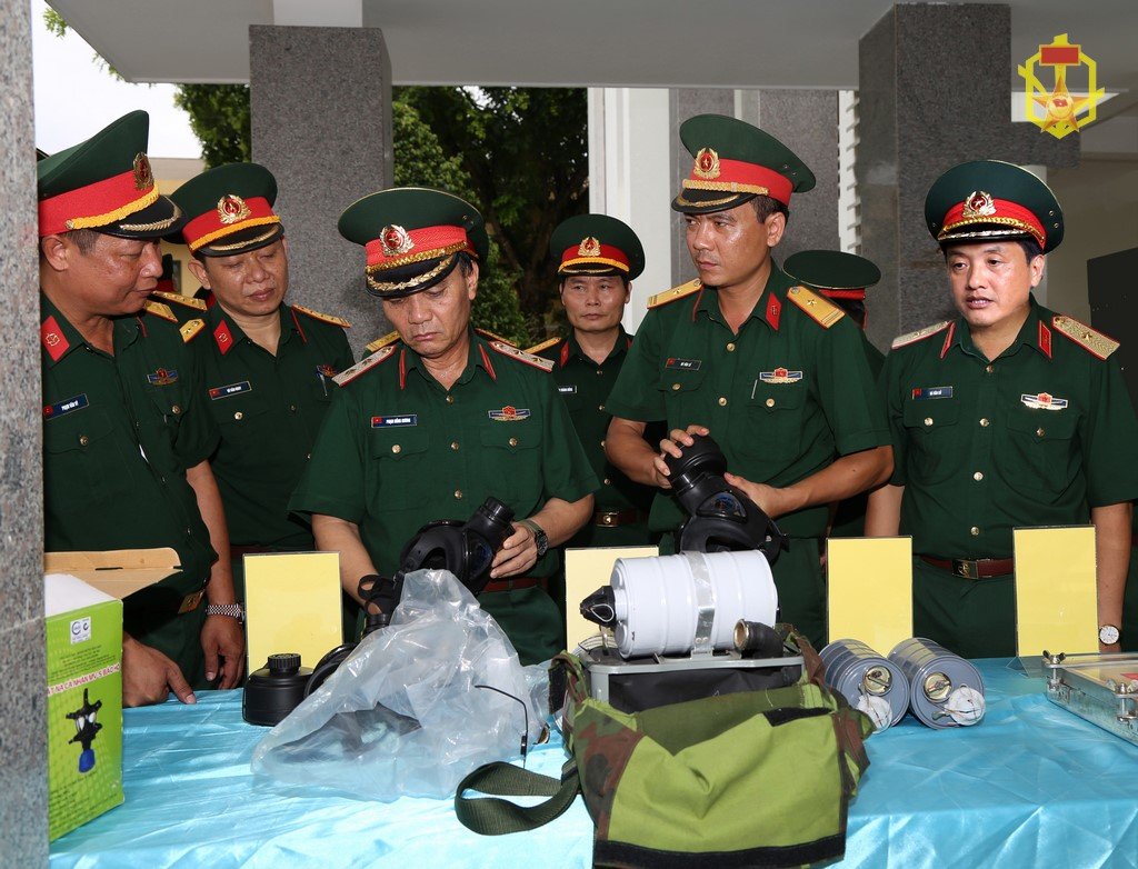 Trung tướng Phạm Hồng Hương, Phó tổng Tham mưu trưởng Quân đội nhân dân Việt Nam (người đứng thứ tư từ phải qua trái) kiểm tra chất lượng mặt nạ phòng độc (MV5) do Nhà máy X61 sản xuất.